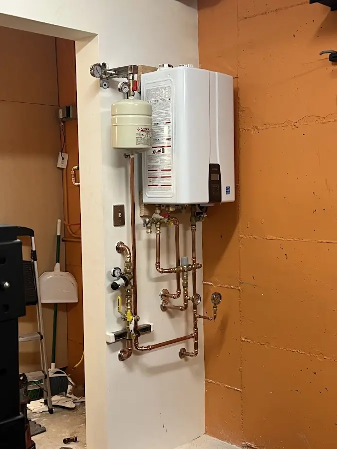 Plumbing technician inspecting water heater connections in San Miguel